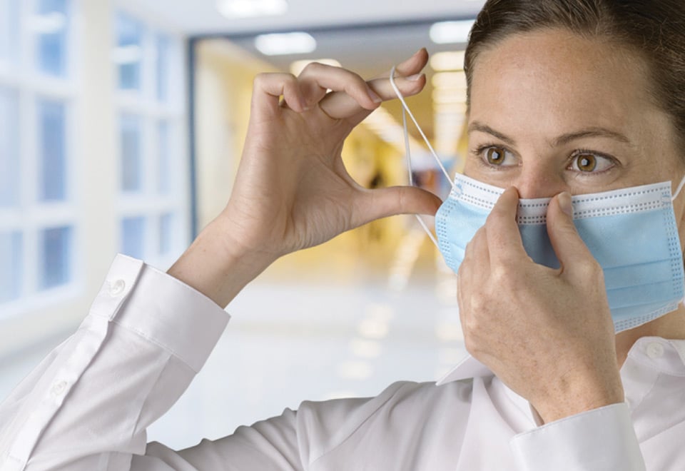 Person placing a mask on inside a clinical environment