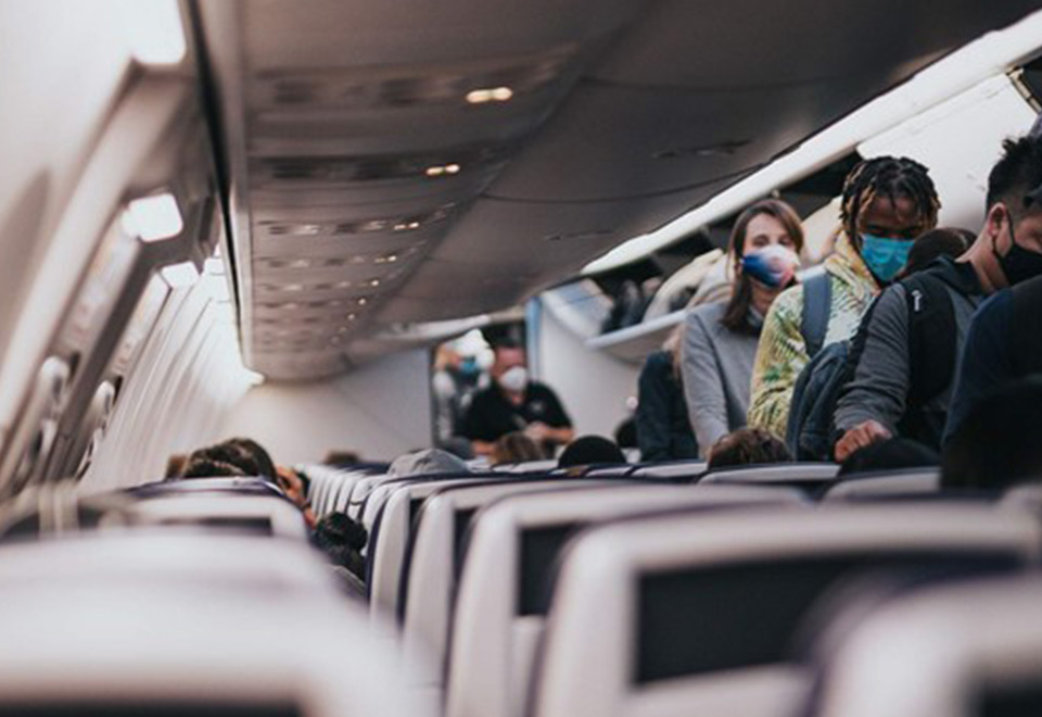 Image of people wearing a mask on an airplane