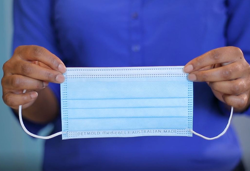 Image of a person holding a Detmold Medical Level 3 surgical mask